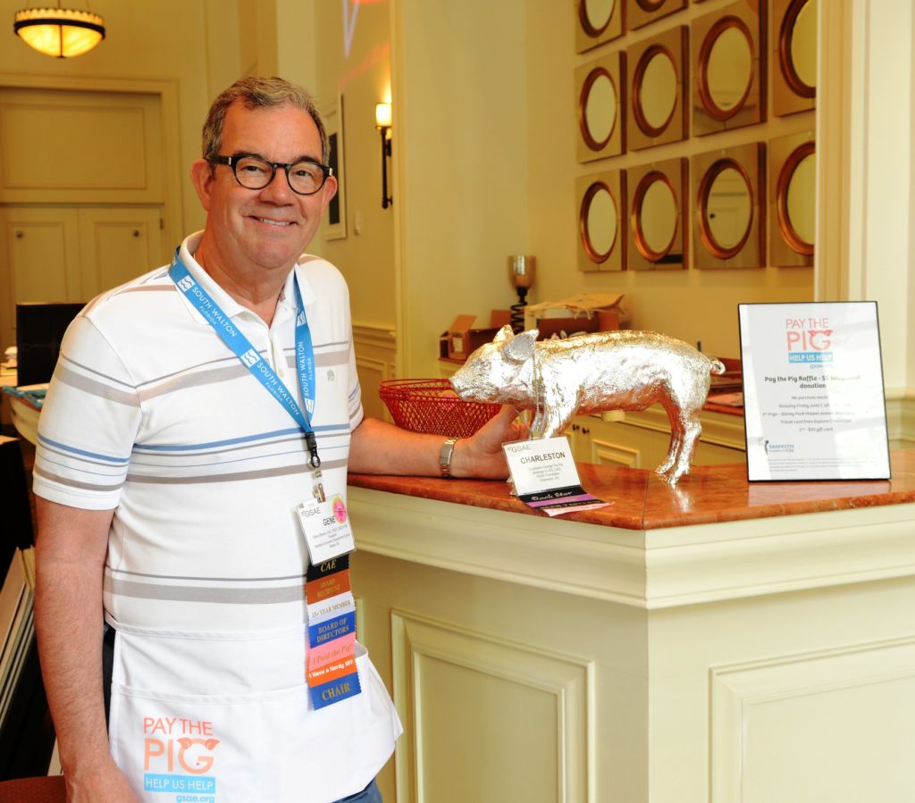 Gene Stinson, CAE, PCED, CEcD, HLM, GSAE Board of Directors chair, debuted the Pay the Pig logo and the use of aprons to promote the raffle in 2018.