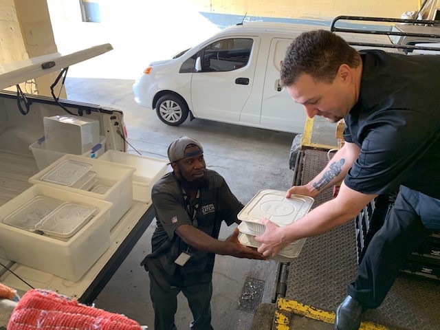 Employees of the Sustainable Events Network, Florida and the Caribbean, load leftover food from FSAE's Annual Meeting into bins for delivery to the Sulzbacher Center, a homeless center that provides housing, health, and job resources to Jacksonville's homeless families.