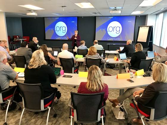 People sitting in a conference room looking at two projector screens for a strategic planning meeting