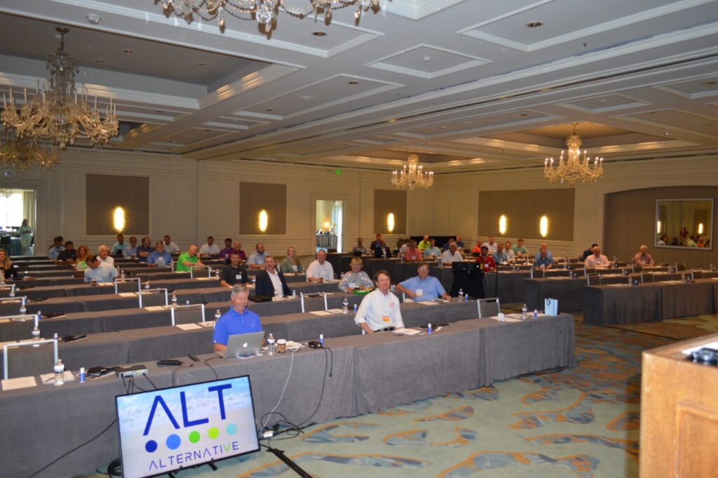 Conference attendees sitting six feet apart at tables